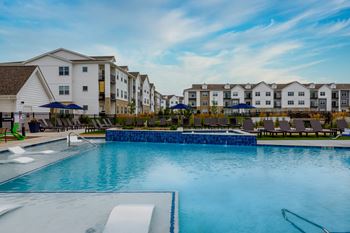 A large swimming pool in front of apartment buildings.
